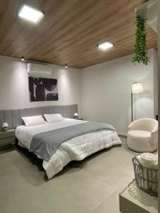 a bedroom with a large bed and a chair at Condômino Max life in Pipa