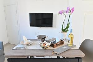 a dining room table with a vase of flowers on it at Congiu's Apartments in Pula