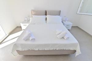 a bedroom with a white bed with towels on it at Congiu's Apartments in Pula
