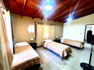 a bedroom with two beds in a room at Chalet con puerta al arroyo in Villa General Belgrano