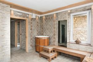 ein Badezimmer mit einer Holzbank und einer Badewanne in der Unterkunft Hotel Al Pelmo in Pieve di Cadore + 21 Fotos