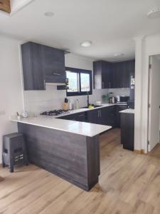 a large kitchen with a large island in a room at Casa Entre Cerros Panimávida in Colbún