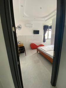 a small room with a bed and a desk at Nhà Nghỉ Phi Yến in Phụng Hiệp