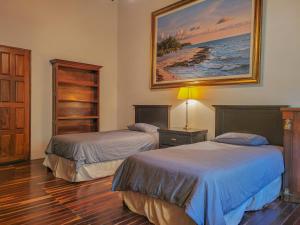 a bedroom with two beds and a painting on the wall at Villas Valle in Valle de Bravo