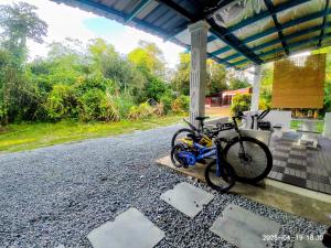 two bikes parked under a building with a porch at Sri Nawa Homestay in Pokok Sena