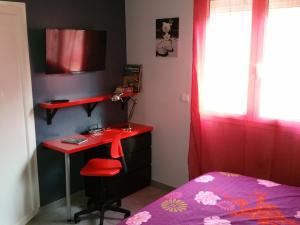 ラ・クロにあるPetit studio au calmeのベッドルーム(赤いデスク、ベッド1台付)
