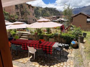 a table with chairs and umbrellas on a patio at Alonso, Fogón & Posada in Chacas