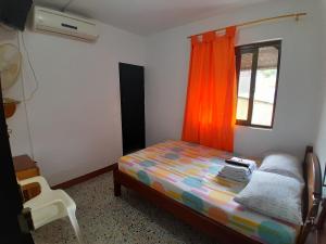 a small bedroom with a bed and a window at Hotel Bruselas Mutata in Mutatá +19 photos