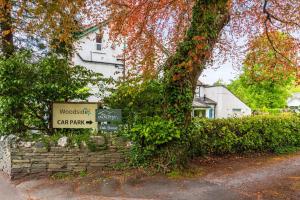 un cartello di fronte a un edificio vicino a un albero di Woodside B & B a Keswick