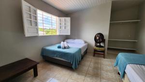 a bedroom with a bed and a chair and a window at GRA325 | Spacious Retreat with Pool and Barbecue. in Gravatá +33 photos