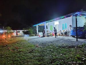 a group of people standing outside of a building at night at Sri Nawa Homestay in Pokok Sena +51 photos
