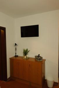 ein Zimmer mit einem Fernseher an der Wand und einer Kommode in der Unterkunft Fünf A in Fürth + 9 Fotos