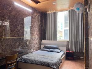 a small bedroom with a bed and a window at Văn An Hotel in Ho Chi Minh City