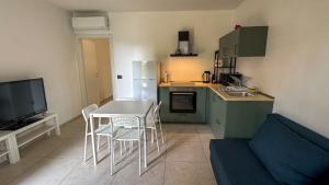a kitchen with a table and chairs and a television at La Cà - Casa Vacanze in Torre De' Roveri