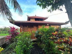 a house in the middle of a garden at Cacao Bamboo House in Krambitan +7 photos