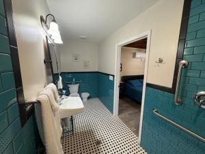 a bathroom with a sink and a blue wall at Historic Ziegler Inn and Suites with Whimsical Themed Rooms in New Bern +80 photos