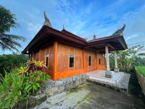 a small building with a porch in front of it at Cacao Bamboo House in Krambitan