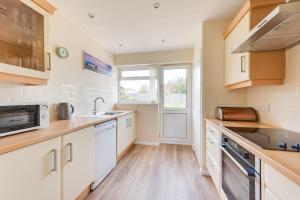 eine Küche mit weißen Schränken und einer Spüle in der Unterkunft 2 Bed in Reydon oc-lowrd in Reydon + 2 Fotos