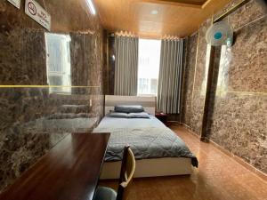 a bedroom with a bed and a table in it at Văn An Hotel in Ho Chi Minh City