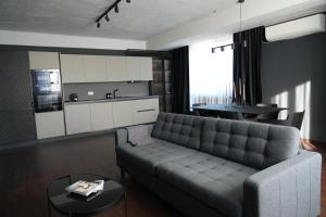 a living room with a couch and a kitchen at Flat 6 - Luxury Designer Apartment in Odăile