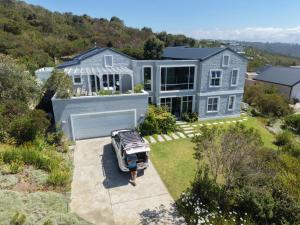 a person standing in front of a house at The Pijper House - Brackenridge Eco Estate Plettenberg Bay in Plettenberg Bay