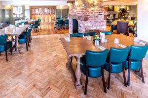 a dining room with tables and chairs and a fireplace at Wheatsheaf Inn, Bar Hill in Onneley +59 photos