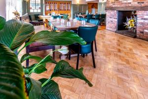 a dining room with a table and chairs and a fireplace at Wheatsheaf Inn, Bar Hill in Onneley