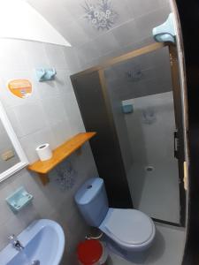 a bathroom with a blue toilet and a shower at Hotel Bruselas Mutata in Mutatá