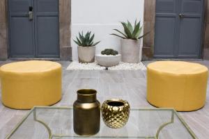 a group of yellow stools and vases on a patio at Markee Hotel Boutique in Quer&eacute;taro