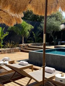 een resort met een zwembad en een parasol bij Hôtel Les Suites Du Maquis in Bonifacio