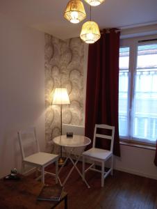 a room with a table and two chairs and a lamp at la pomme d'amour in Sully-sur-Loire