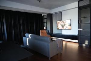 a living room with a couch and a chair at Flat 6 - Luxury Designer Apartment in Odăile