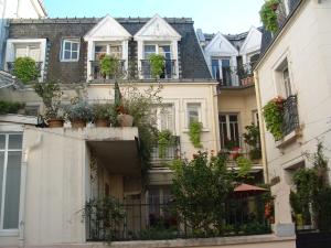 une rangée de maisons avec des plantes en pot sur les balcons dans l'établissement Hotel California, à Vichy