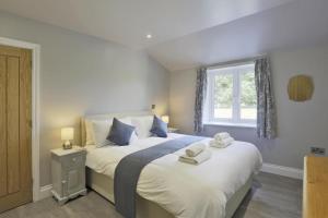 a bedroom with a large white bed with a window at 3 Bed in Barsham oc-bbarn in Beccles