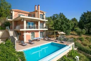 a house with a swimming pool in front of it at Villa Chrissos by Villa Plus in Lourdata