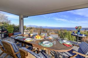 a dining room with a table and chairs and a large window at Villa Mirador in Padenghe sul Garda