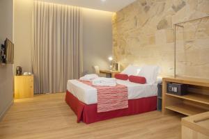 Habitación de hotel con cama y pared de piedra en Soho Boutique Capuchinos & Spa en Córdoba