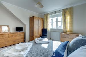 a bedroom with a bed and a dresser and a television at 2 Bed in Southwold oc-scl in Reydon