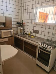 a small kitchen with a stove and a sink at House in Iriri in Anchieta +15 photos