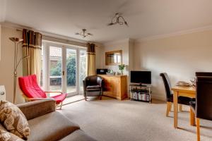 a living room with a couch and a desk and a television at 2 Bed in Southwold oc-scl in Reydon