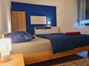 a bedroom with a bed with a blue wall at OLD TOWN ROAD in Karlovac