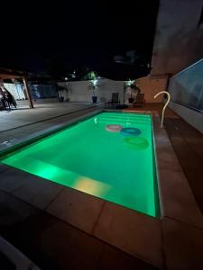 a swimming pool at night with a green illumination at House in Iriri in Anchieta