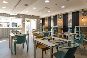 a restaurant with tables and chairs and clocks on the walls at Porta 30 in Oeiras