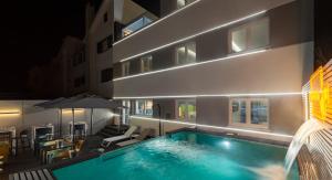 a swimming pool in front of a building at night at Porta 30 in Oeiras