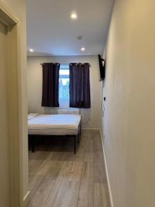 a small room with a bed and a window at Brigstock 4 in Thornton Heath +1 photo