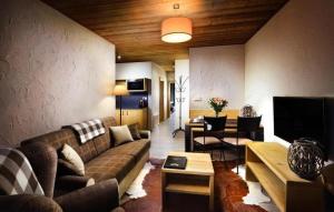 a living room with a couch and a tv at Chalets Jasná Centrum APT KROWKA - Free Jacuzzi & Sauna and Chopok view in Belá