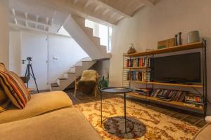 a living room with a couch and a tv at Villa des Amandes in Bédarieux