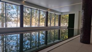 an empty room with large windows and trees at Blue&Green Masurian Hotel in Węgorzewo