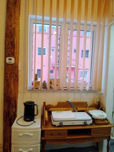 a room with a table with a microwave and a window at Happy Place Apartment in Lupeni