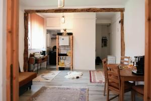 a living room with a table and a refrigerator at Happy Place Apartment in Lupeni